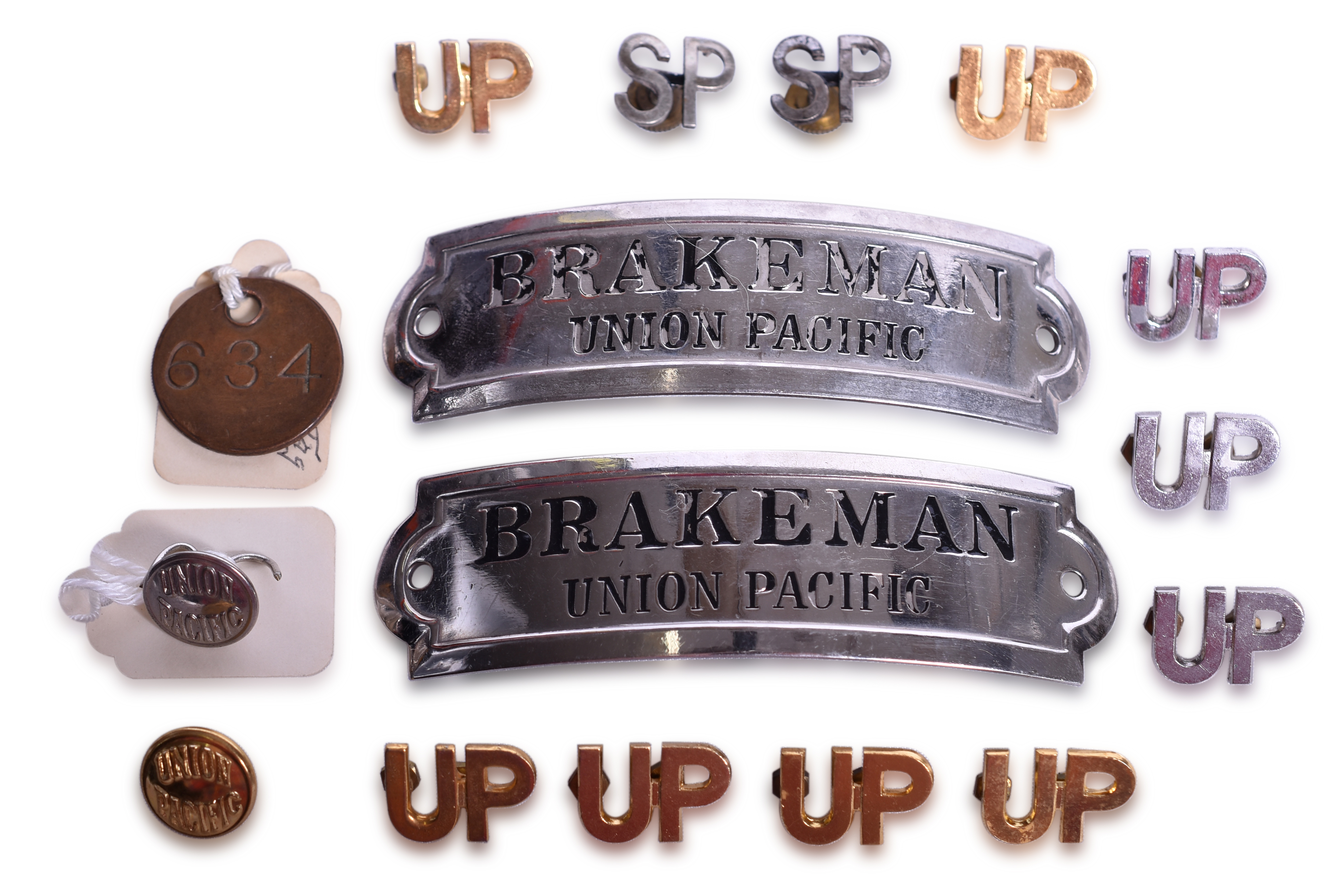 2127 - Group of Sixteen Union Pacific and Southern Pacific Railroad Items - Brakeman Cap Badges, Lapel Pins, Buttons, and Brass Tool Tag thumbnail