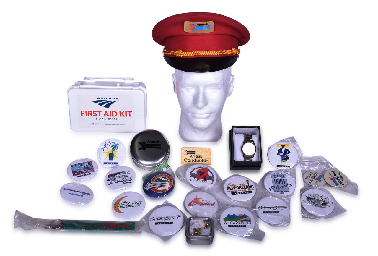 2629 - Twenty-Four Amtrak Railroad Items - Conductor Hat Badge, Cap, Watches, Buttons, First Aid Kit, and More Promotional Items thumbnail