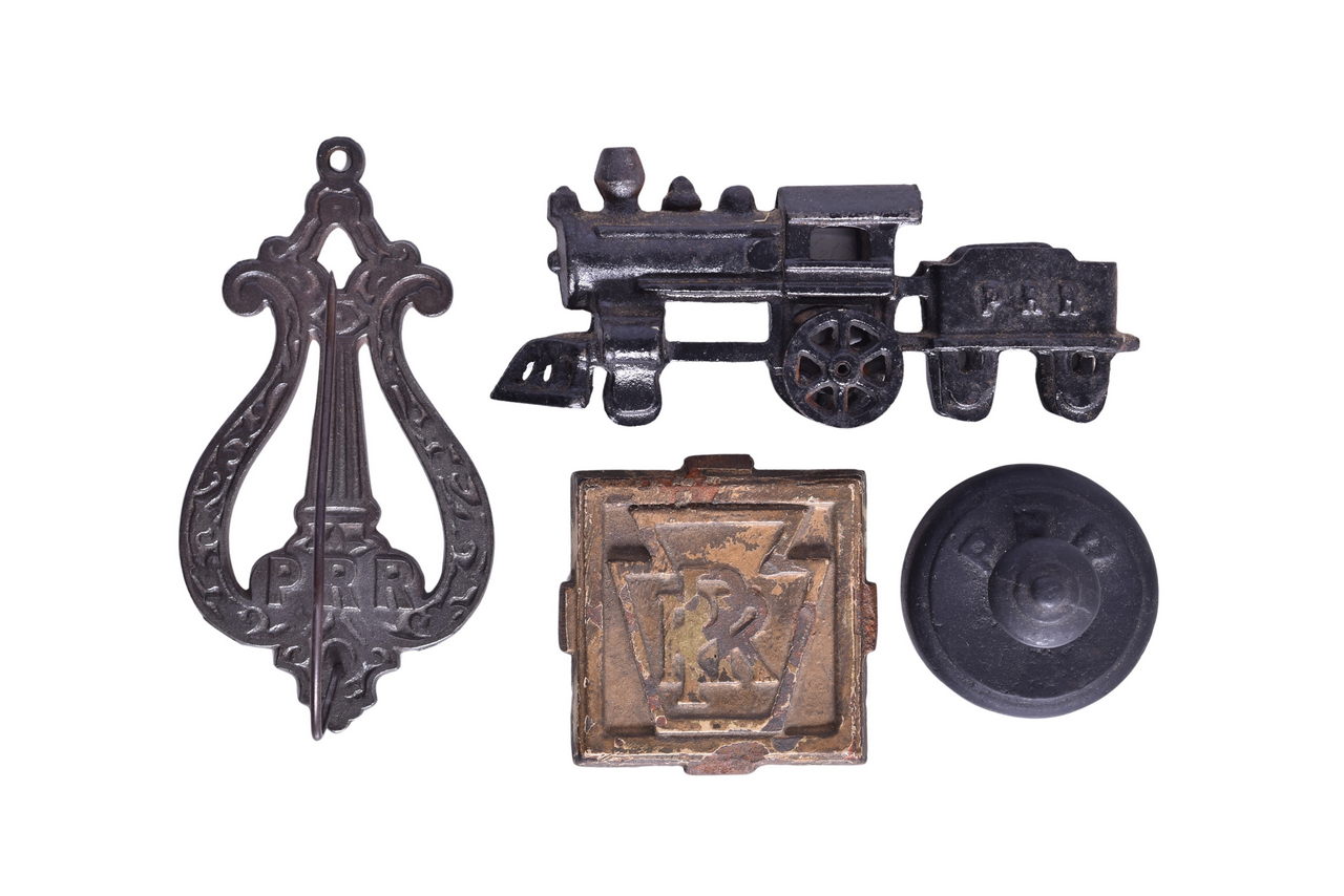 4437 - Four Cast Iron Pennsylvania Railroad Items - Depot Bill Hook, Paper Weights, and Toy Train Locomotive thumbnail